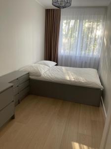 a small bedroom with a bed and a window at Apartament Kasztanowa in Augustów