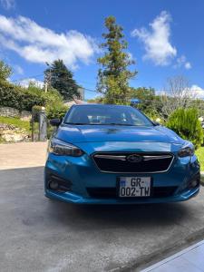 a blue car parked in a driveway at Hotel Green Town in Kutaisi