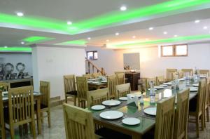 a dining room with tables and chairs and green lights at Hotel Leh Residency -Leh in Leh