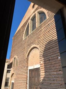 een hoog bakstenen gebouw met een deur en ramen bij Campo San Lorenzo in Venetië