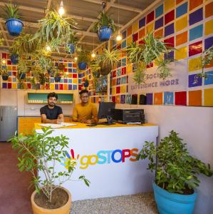 dos hombres sentados en una recepción con plantas en goSTOPS Jaipur, en Jaipur