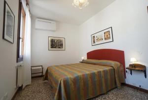 een slaapkamer met een bed in een witte kamer bij Campo San Lorenzo in Venetië
