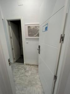 a hallway with a door in a room with a tile floor at The Spot Central Hostel in Seville