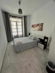 sypialnia z łóżkiem i dużym oknem w obiekcie The Spot Central Hostel w Sewilli