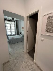 een slaapkamer met een bed en een deur naar een kamer bij The Spot Central Hostel in Sevilla