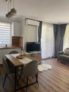 sala de estar con mesa, sillas y TV en M&M Center Apartment with free parking en Plovdiv