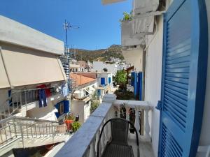 a balcony with a blue door and white buildings at Studios IRENE in Fournoi