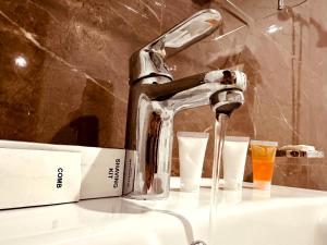 纳兰恩Kunhar Hotel RiverSide Block的浴室水槽配有水龙头和2个玻璃杯