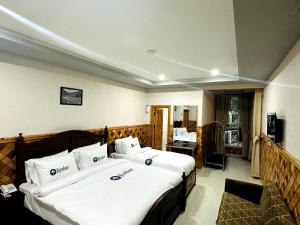 Habitación de hotel con 2 camas y TV en Kunhar Hotel RiverSide Block en Naran