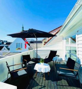 a patio with a table and an umbrella at Central Stavanger Guesthouse in Stavanger