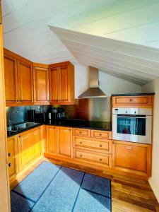 a kitchen with wooden cabinets and a stove top oven at Central Stavanger Guesthouse in Stavanger