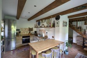 eine große Küche mit einem Holztisch und Stühlen in der Unterkunft Walnut Tree Cottage in Săcele