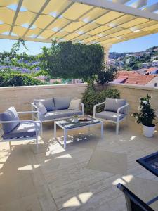 a patio with two couches and a coffee table at Apartment Making memories in Pučišća