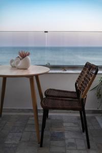 a table and a chair with a view of the ocean at Porto Lygia Apartment in Ierápetra