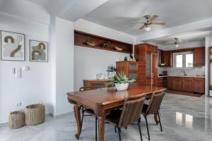 a kitchen with a wooden table and chairs at Porto Lygia Apartment in Ierapetra