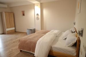 a bedroom with a bed with white sheets and pillows at h’Olarooms N3 in Tʼianetʼi