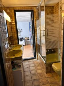 uma casa de banho com um lavatório, um chuveiro e uma banheira em Zuidwest Zeven free parking! em Zandvoort