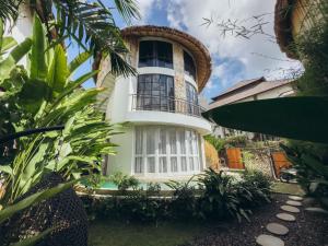 a large white house with a balcony at Hillstone U Villa in Uluwatu