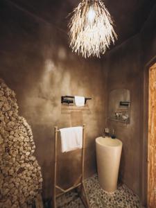 a bathroom with a sink and a chandelier at Hillstone U Villa in Uluwatu