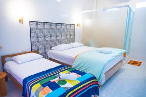 two beds in a hotel room withthritisthritislictslictslicts at Jo&Jo Hostel in Bandar Lampung