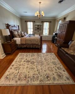 ein Schlafzimmer mit einem Bett und einem Teppich auf dem Boden in der Unterkunft Opus House Historic Natchitoches in Natchitoches
