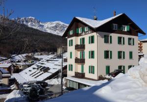a building with green windows and snow covered roofs at Residence Villa Viola in Andalo