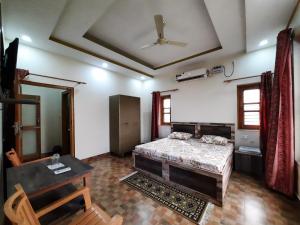 - une chambre avec un lit, une table et un plafond dans l'établissement Bora's Homestay, à Haldwani