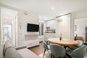 a living room with a couch and a table and chairs at apartamento en la puerta del sol in Madrid