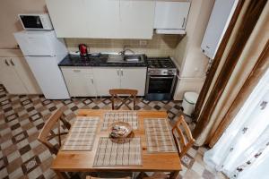 eine kleine Küche mit einem Tisch, Stühlen und einem Waschbecken in der Unterkunft Luxury Radox Apartment Airport Bucharest 2 in Otopeni