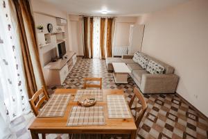 ein Wohnzimmer mit einem Sofa und einem Tisch in der Unterkunft Luxury Radox Apartment Airport Bucharest 2 in Otopeni