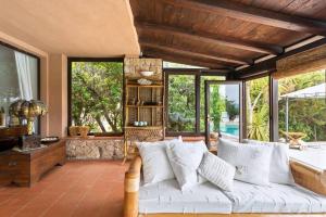 a living room with a white couch and large windows at Villa Dina with Pool - Costa Paradiso in Costa Paradiso