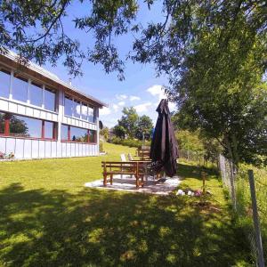 a patio with a table and an umbrella and a bench at Holiday home Vila Bjelašnica in Bjelašnica