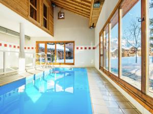 a swimming pool in a house with windows at Attractive apartment with a balcony in Le Grand Massif in Samoëns