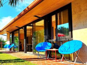 eine Gruppe blauer Stühle vor einem Gebäude in der Unterkunft House&Yard Hellen 150m to beach in Ureki