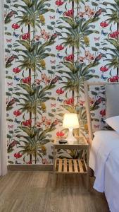 - une chambre avec un mur orné d'un papier peint à fleurs dans l'établissement Donna Luisa-Catania Charming, à Catane