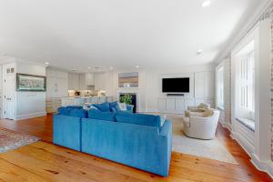 a living room with a blue couch and a kitchen at Rainbow Row Pied-A-Terre in Charleston