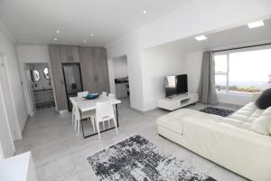 a living room with a white couch and a table at Villa Plaza in Shelly Beach