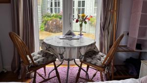 una mesa y dos sillas con un jarrón de flores. en Mole End, en Withypool
