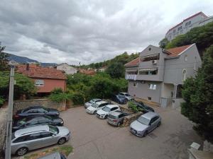 un gruppo di auto parcheggiate in un parcheggio di Guesthouse Hortenzija a Mostar