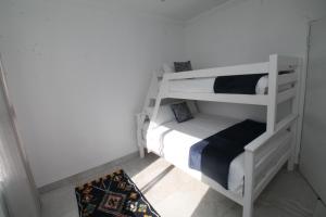 a small room with two bunk beds and a rug at Villa Plaza in Shelly Beach