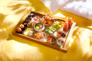 uma bandeja cheia com diferentes tipos de comida numa cama em The Lemon Suites em Deventer