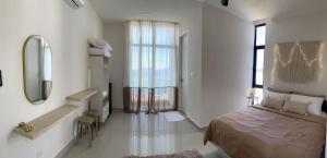 The Seashore House, The Shore Kota Kinabalu في كوتا كينابالو: غرفة نوم بسرير ومرآة ومغسلة