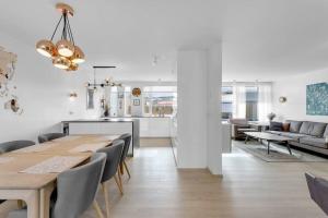 ein Esszimmer und eine Küche mit einem Tisch und Stühlen in der Unterkunft Venture Vacation-Family Friendly Retreat-HOT TUB in Mosfellsbær
