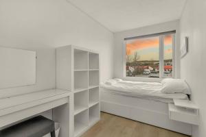 a white bedroom with a bed and a window at Venture Vacation-Family Friendly Retreat-HOT TUB in Mosfellsbær