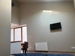 a living room with a tv on a white wall at Studio 25m2 neuf in Châtillon