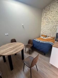 1 dormitorio con 1 cama, mesa y sillas en Studio 25m2 neuf en Châtillon