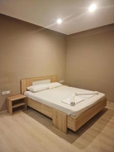 a bedroom with a large bed with white sheets at VILIN in Niš