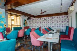 um restaurante com cadeiras e mesas cor-de-rosa e azul em Hotel DOON em Dehradun