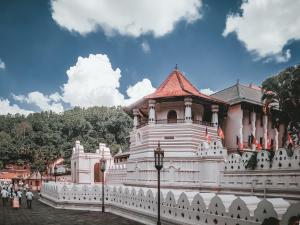 a large white building with a red roof at Orchard Home in Kandy
