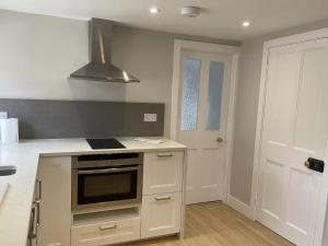 a kitchen with a stove top oven next to a door at The Greig 1A in Wadhurst
